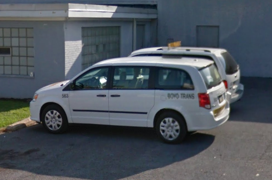 Several BOYO school vans in a parking lot.